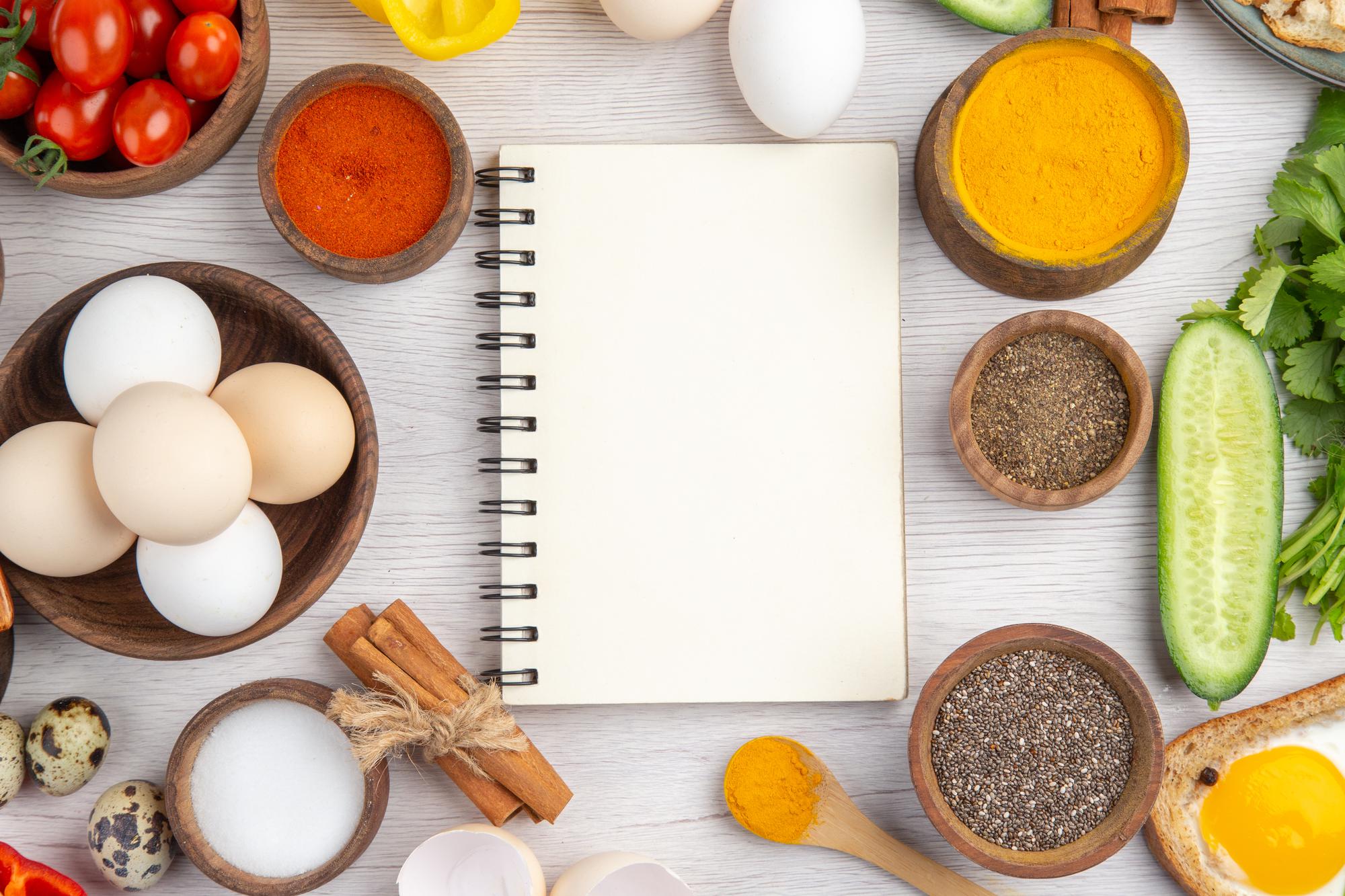 Mesa com ingredientes e caderno de receitas